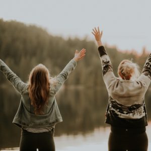 Practical spirituality for our relationships: Two Women holding hands up to the sky