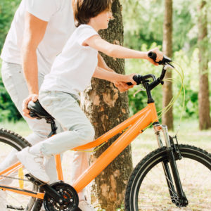 Man teaching child to ride a bicycle